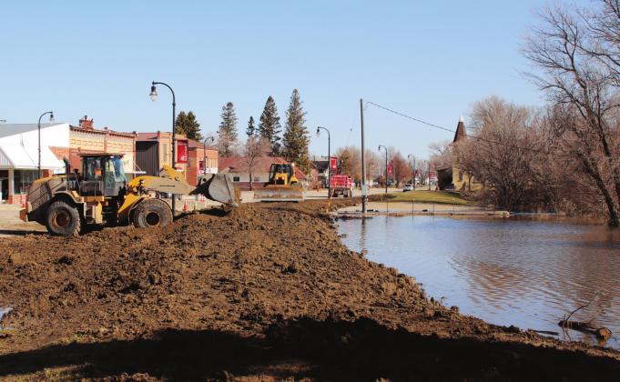 Tuesday morning crews from Helms and Blawats were busy rasing the temporary dikes another foot. Pictured is the parking lot across from KodaBank looking to the north. VNV phot by Lyle Van Camp