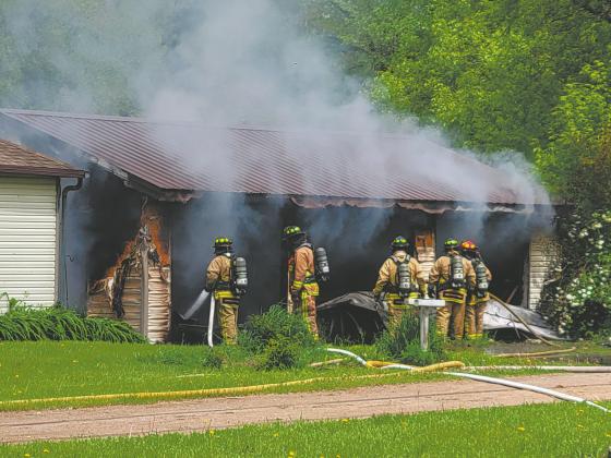 Members of the Grafton Volunteer Fire Department assess the damage and look for hot spots in the garage at 116 Wakeman Avenue in Grafton Monday afternoon. Photo by Mike Steinfeldt.